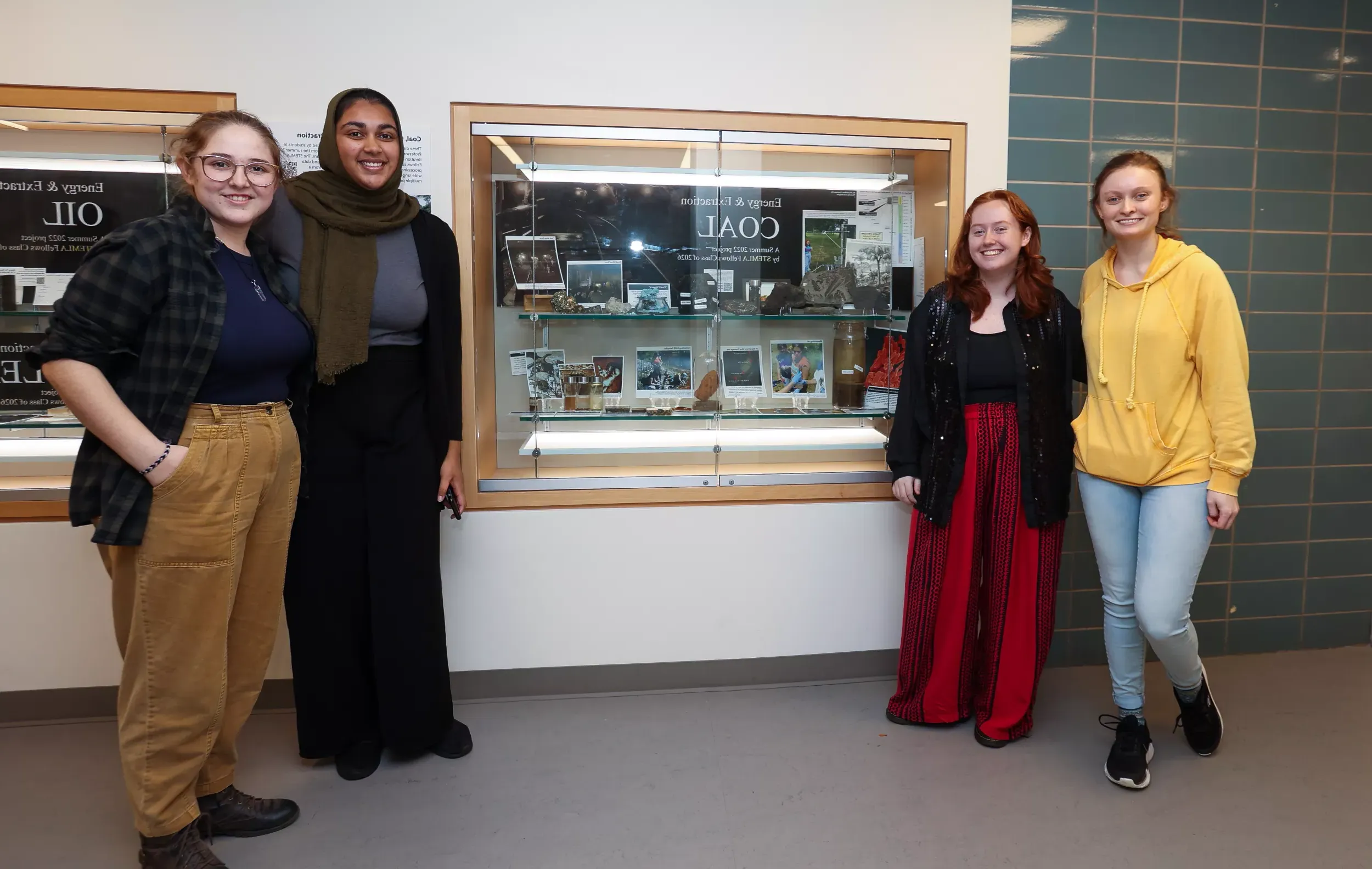 STEMLA Fellows post in front of display case