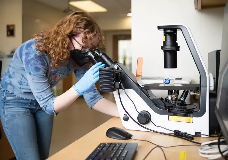 Caelin looks into a microscope